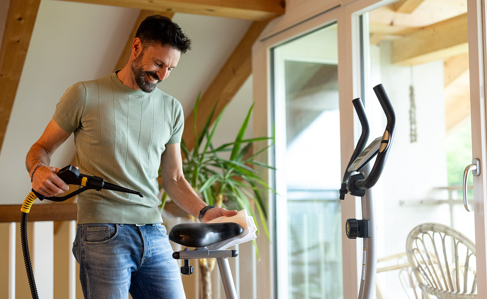 Mann reinigt sein Heimtrainer-Fahrrad zuhause mit dem Thermostar Trockendampfreiniger